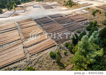 Aerial view of sawmill with timber, chopped a lot of pine tree wood logs. Top, drone view Aerial view of sawmill with timber, chopped a lot of pine tree wood logs. Top, drone view 94043360