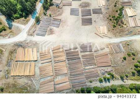 Aerial view of sawmill with timber, chopped  a lot of pine tree wood logs. Top, drone view Aerial view of sawmill with timber, chopped  a lot of pine tree wood logs. Top, drone view 94043372