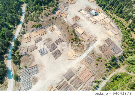 Aerial view of sawmill with timber, chopped  a lot of pine tree wood logs. Top, drone view Aerial view of sawmill with timber, chopped  a lot of pine tree wood logs. Top, drone view 94043378