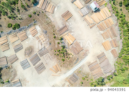 Aerial view of sawmill with timber, chopped  a lot of pine tree wood logs. Top, drone view 94043391
