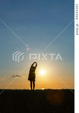 光の中で伸びをする女性 光の中で伸びをする女性 94044365