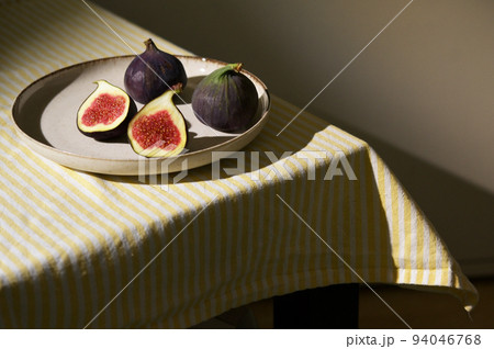 Figs fruits placed on a small plate on a table with a tablecloth 94046768