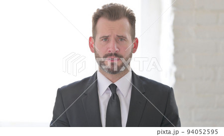 Middle Aged Businessman Looking at the Camera, Sad Expression Middle Aged Businessman Looking at the Camera, Sad Expression 94052595