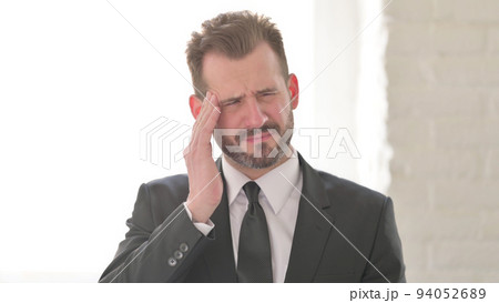 Tense Middle Aged Businessman having Headache Tense Middle Aged Businessman having Headache 94052689