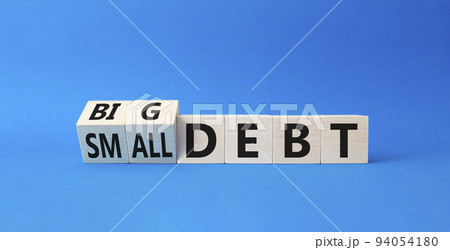 Big debt and small debt symbol. Turned cubes with words Big debt and small debt. Beautiful blue background. Business concept. Copy space Big debt and small debt symbol. Turned cubes with words Big debt and small debt. Beautiful blue background. Business concept. Copy space 94054180