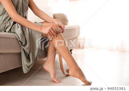 Beautiful woman putting on tights indoors, closeup Beautiful woman putting on tights indoors, closeup 94055361