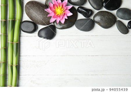 Stones, bamboo, lotus flower and space for text on white wooden background, flat lay. Zen lifestyle 94055439
