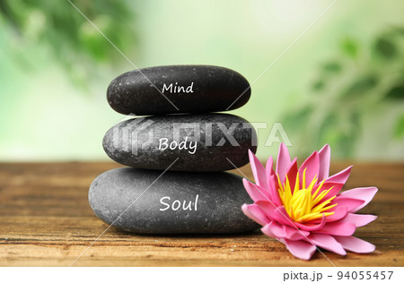 Stones with words Mind, Body, Soul and lotus flower on wooden table. Zen lifestyle Stones with words Mind, Body, Soul and lotus flower on wooden table. Zen lifestyle 94055457