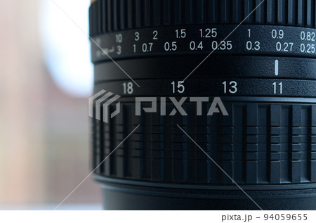 Fragment of a wide angle zoom lens for a modern SLR camera. The set of distance values is indicated by white numbers on the black body Fragment of a wide angle zoom lens for a modern SLR camera. The set of distance values is indicated by white numbers on the black body 94059655