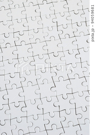 Close up texture of a white jigsaw puzzle in assembled condition. Top view. Many components of a large whole mosaic are united Close up texture of a white jigsaw puzzle in assembled condition. Top view. Many components of a large whole mosaic are united 94059681