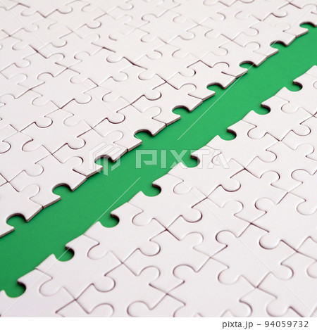 The green path is laid on the platform of a white folded jigsaw puzzle. Texture image with copy space for text The green path is laid on the platform of a white folded jigsaw puzzle. Texture image with copy space for text 94059732