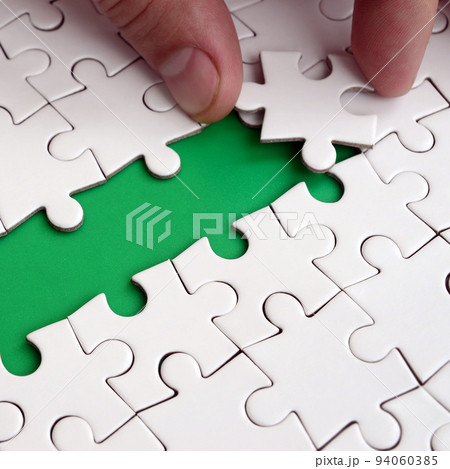 The human hand paves the way to the surface of the jigsaw puzzle, forming a green space. The concept of overcoming the difficulties on the way to success The human hand paves the way to the surface of the jigsaw puzzle, forming a green space. The concept of overcoming the difficulties on the way to success 94060385