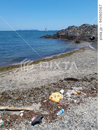 ボートの浮かぶ海と砂浜に散らばるごみ ボートの浮かぶ海と砂浜に散らばるごみ 94060567