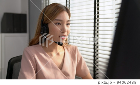 Competent female operator working on computer and while talking with clients. Competent female operator working on computer and while talking with clients. 94062438