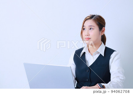 デスクワーク中に時間を気にする若い女性 94062708