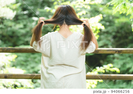 森の中で髪の毛を縛る女性(ふたつ結び) 森の中で髪の毛を縛る女性(ふたつ結び) 94066256