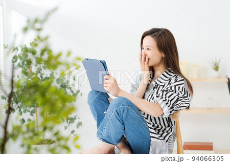 タブレット端末を見る女性 94066305