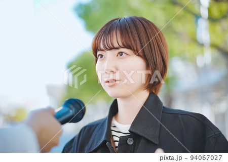 街頭インタビューを受ける女性  94067027