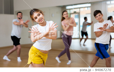Young girl exercising aerobic dance with family Young girl exercising aerobic dance with family 94067270