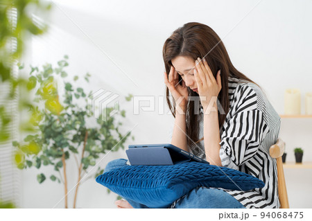 タブレット端末を見る女性 94068475