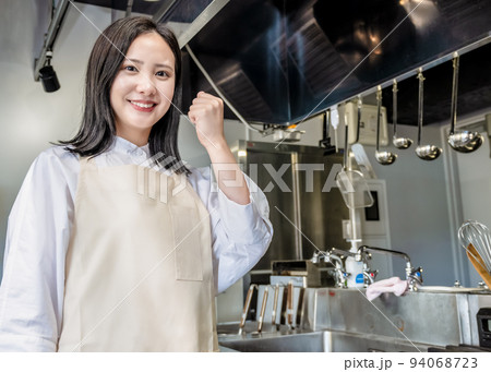 レストランの厨房を紹介する若い女性　ガッツポーズ 94068723