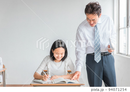学校・塾で授業を受けて勉強する子供とアジア人の先生・講師（小学生・中学生・高校生） 94071254