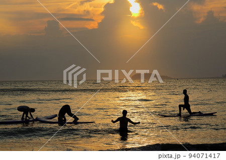 夏の逗子海岸、夕陽に染まる海でSUPヨガを楽しむ人々 夏の逗子海岸、夕陽に染まる海でSUPヨガを楽しむ人々 94071417