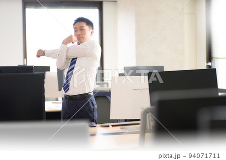 仕事の合間にストレッチをするビジネスマン 94071711