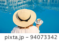 woman holds a white cup of coffee in her hands on the background of a blue swimming pool. Good 94073342