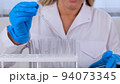 professional scientist takes a sample for a medical experiment. A research chemist works in a 94073345