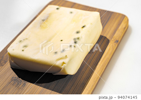 a pack of spoiled butter with mold on a wooden board 94074145