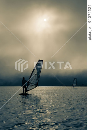 windsurfer silhouette on sunset background windsurfer silhouette on sunset background 94074524