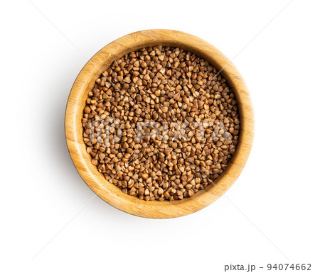 Uncooked buckwheat grain in scoop isolated on white background. Uncooked buckwheat grain in scoop isolated on white background. 94074662