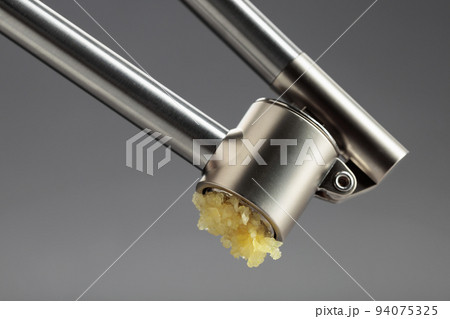 Squeeze the garlic with a garlic press. 94075325