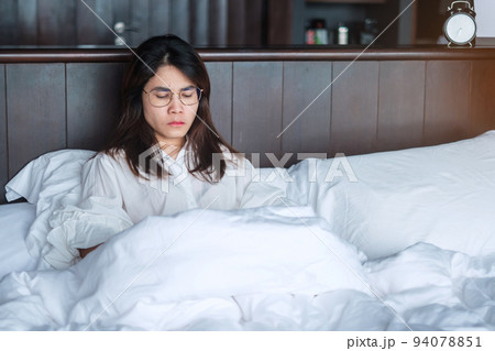 woman having migraine headaches during lying in bed at home. insomnia, sleepless, tired, suffering and stressed concepts 94078851