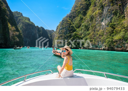 Woman tourist on boat trip, happy traveller relaxing at Pileh lagoon on Phi Phi island, Krabi, Thailand. Exotic landmark, destination Southeast Asia Travel, vacation and holiday concept 94079433