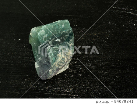 Fluorite fluorspar from Brazil. Natural mineral stone on black background. Mineralogy, geology, magic of stones, semi-precious stones and samples of minerals. Close-up macro photo. 94079841