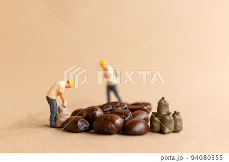 Miniature worker team working with coffee beans Miniature worker team working with coffee beans 94080355