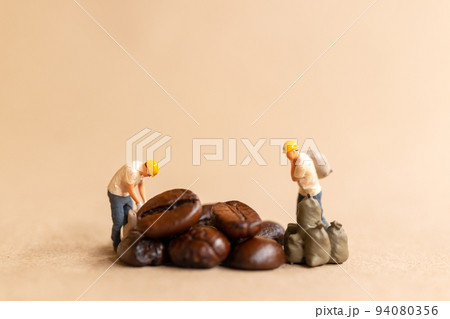 Miniature worker team working with coffee beans 94080356