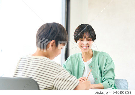 勉強を教える女性 勉強をする小学生 勉強を教える女性 勉強をする小学生 94080853