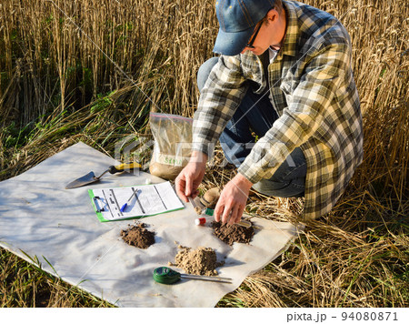 Agronomist preparing soil samples for laboratory analysis outdoors Agronomist preparing soil samples for laboratory analysis outdoors 94080871