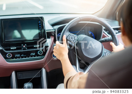woman driver driving a car on the road, hand controlling steering wheel in electric modern automobile. Journey, trip and safety Transportation concepts woman driver driving a car on the road, hand controlling steering wheel in electric modern automobile. Journey, trip and safety Transportation concepts 94083325