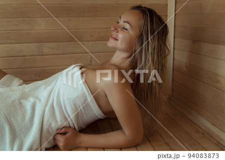 Beautiful young woman relaxing in Finnish sauna 94083873