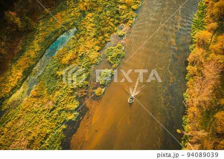 Aerial view of forest woods, marsh bog and river in sunny autumn landscape. Bird's eye view. Top view of beautiful european nature from high attitude in autumn season. Drone view 94089039