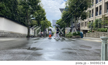 夏の雨の日に神戸の北野異人館の街で散歩している親子の姿 94090258
