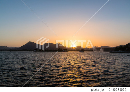 インド　ウダイプルのフェイ・サガー・レイクと夕焼けでオレンジ色に染まった空 94093092