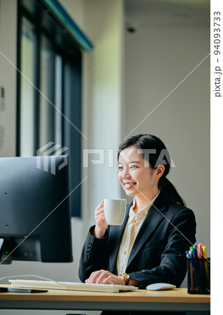 オフィスでコーヒーを飲む若い女性 94093733