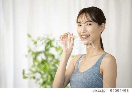 片手でマウスピースを持つ女性 94094498