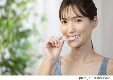 片手でマウスピースを持つ女性 94094502