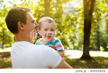Dad plays with his little son in the garden outdoors. Family pastime. Happy smiling people. Boy of one and a half years. Toddler. Selective focus 94094609